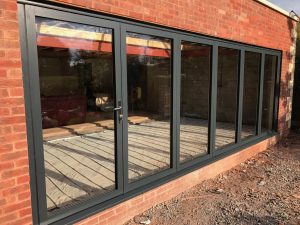 swing and slide door in black frame against orange brick wall